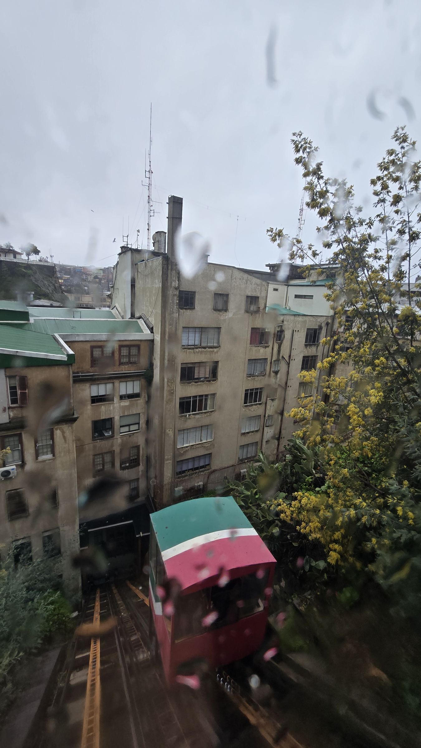 Un ascensor de Valparaíso visto desde una ventana, con casas de colores en el cerro