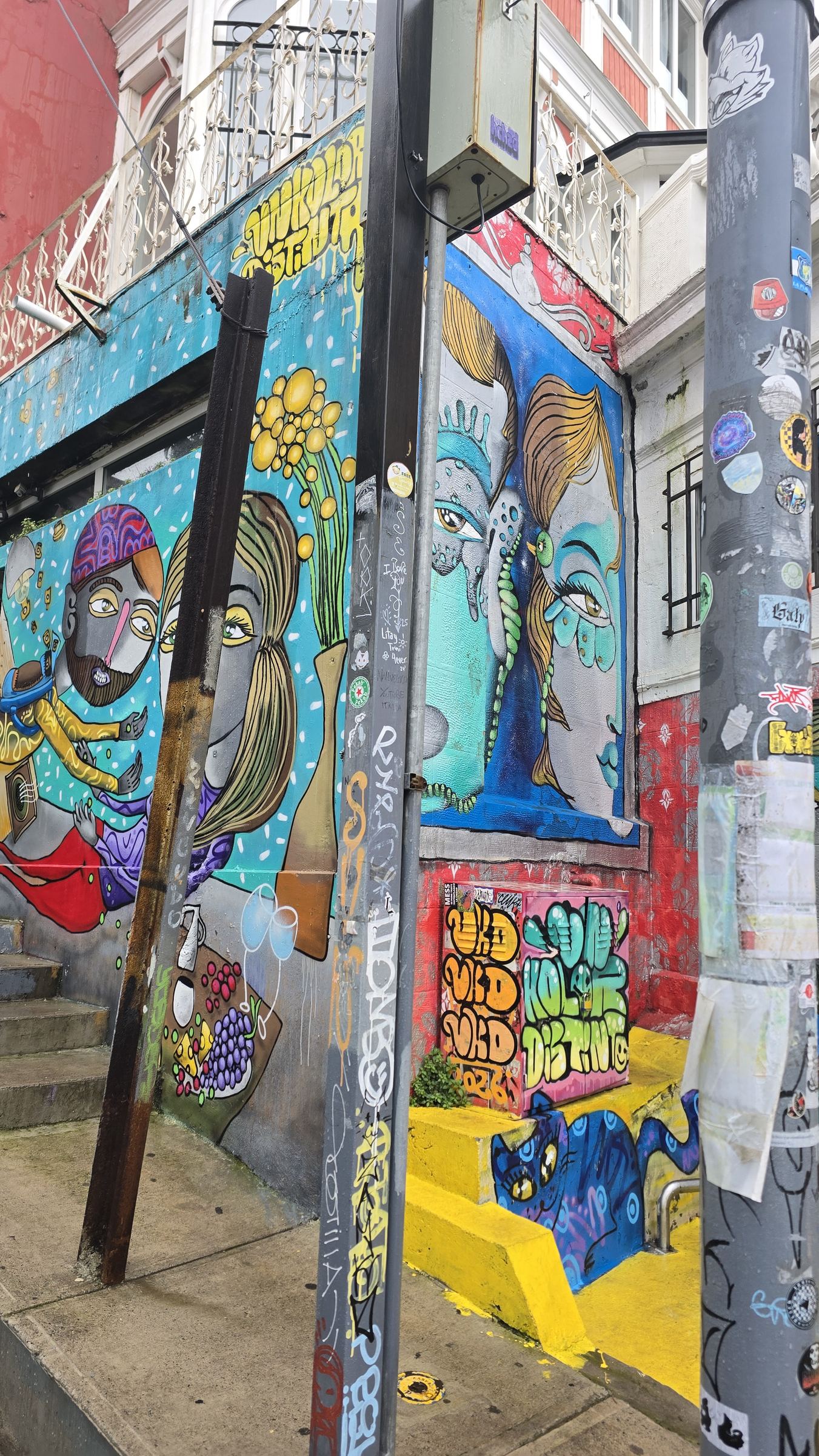 Un mural de colores con dos rostros pintados, en una calle de Valparaíso