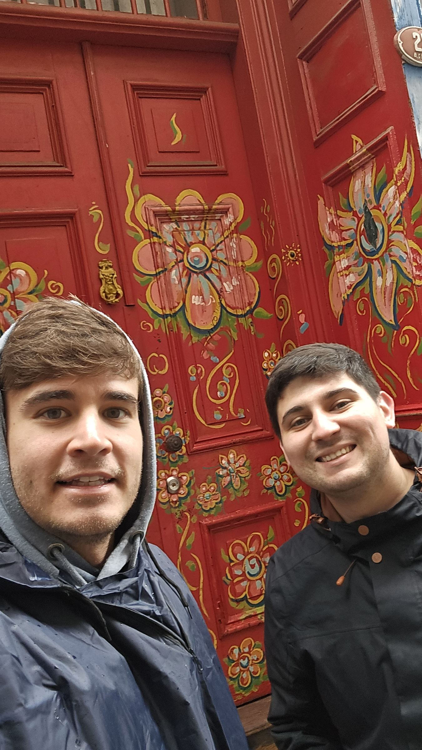 Nacho y yo frente a una puerta pintada con flores, en una calle de Valparaíso