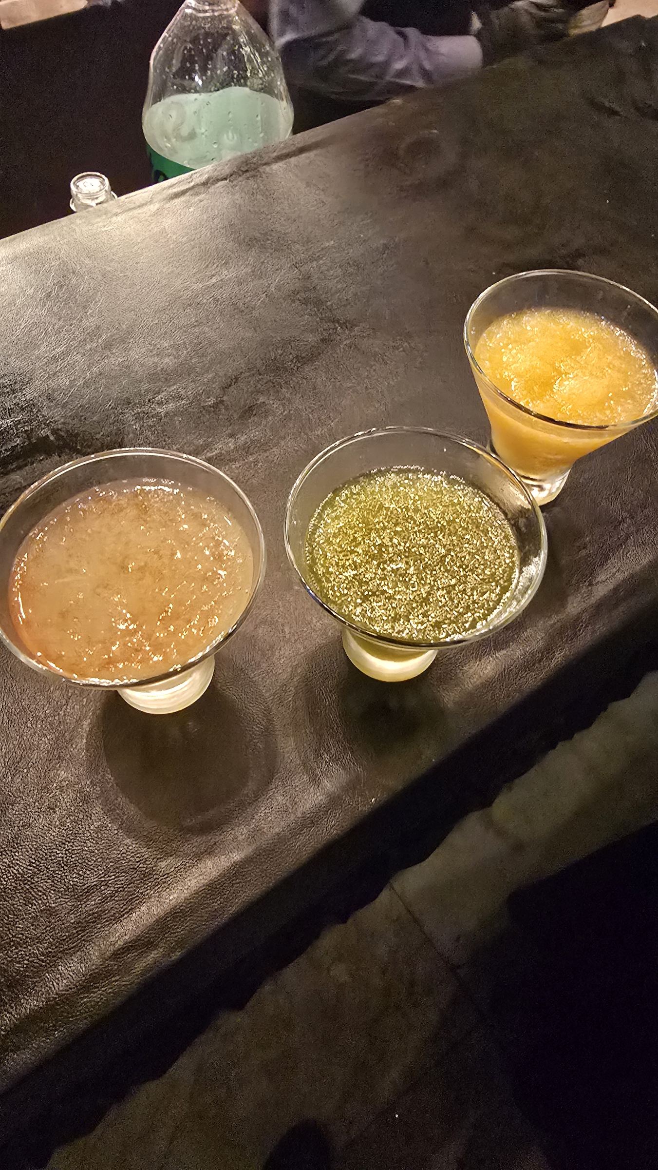 Tres cócteles de colores sobre una barra, en la fiesta